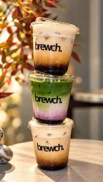 Three layered Brewch iced drinks with autumn leaves behind them.